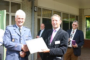 Air Cdre. Gerrit Schoonderbeek, RNLAF (Ret.) (r), chapter vice president, presents a token of appreciation to Lt. Col. Klaas Gomes, RNLAF, project manager, MilSatCom, for speaking at the June meeting.